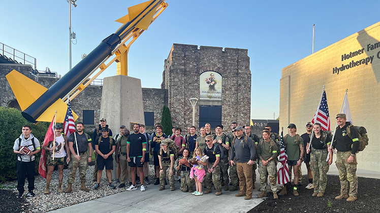 Photo of Student Veterans of America groups at The University of Toledo and Bowling Green State University posing at UToledo in front of the rocket at the Glass Bowl. The groups joined forces last Saturday to deliver and present the game ball to officials in their third annual “Ruck the Ball” 24-mile march leading up to the annual Battle of I-75 football matchup between the Rockets and the Falcons at Bowling Green this Saturday, Oct. 11.