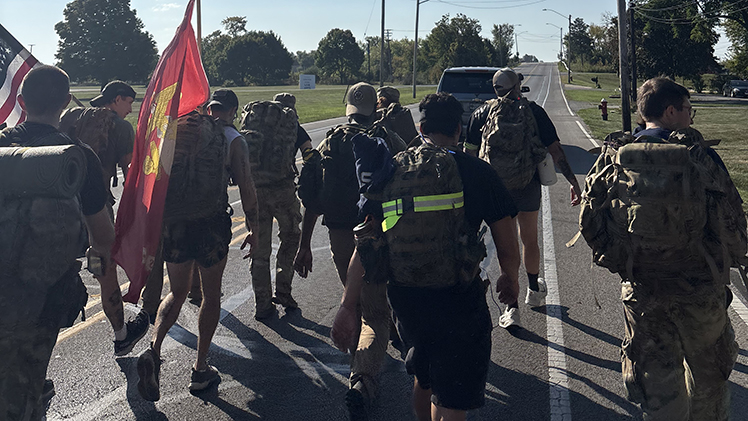 Photo of marching Student Veterans of America groups at The University of Toledo and Bowling Green State University, who joined forces last Saturday to deliver and present the game ball to officials in their third annual “Ruck the Ball” 24-mile march leading up to the annual Battle of I-75 football matchup between the Rockets and the Falcons at Bowling Green this Saturday, Oct. 11.