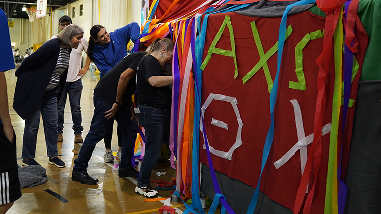 Piper Pierce, a nursing junior, center right, showcases the finished tent of Alpha Chi Omega and Theta Chi to Geni Hofbauer, Mortar Board National Senior Honor Society advisor.