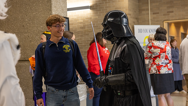 UToledo Provost Mitchell McKinney, dressed as Darth Vader, talks with Student Government Vice President Jaden Bollinger, a senior in political science, during the Provost’s Power and Peril Halloween Party held earlier today in Thompson Student Union. The Halloween event provided treats and games to play for students.