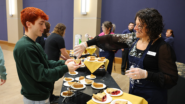 Joshua Kohler, a first-year graduate student in speech-language pathology, gets whipped cream for his cherry pie from Mandy Corbin, program manager, Licensure for Judith Herb College of Arts, Social Sciences and Education.