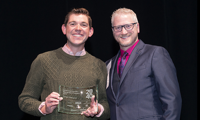 Daniel Pfaltzgraf, an instructor in the John B. and Lillian E. Neff College of Business and Innovation, receives his "20 Under 40" award, standing next to the award's presenter.