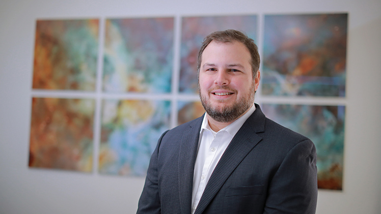 Portrait of Dr. Eli Visbal, an associate professor of astronomy, who is a theorist who specializes in mathematical models of the early universe.