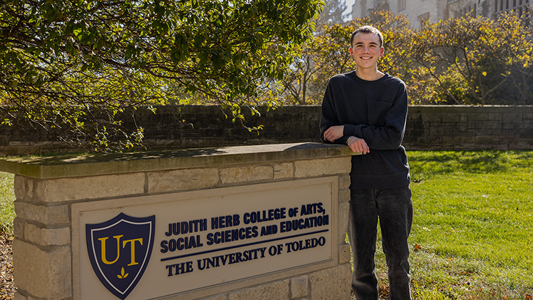 Fifth-generation Rocket and education major Grayson Gallaher stands next to the Judith Herb College of Arts, Social Sciences and Education.