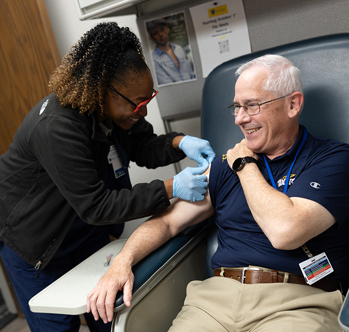 UToledo President Holloway receives a flu shot from a UToledo Health nurse.