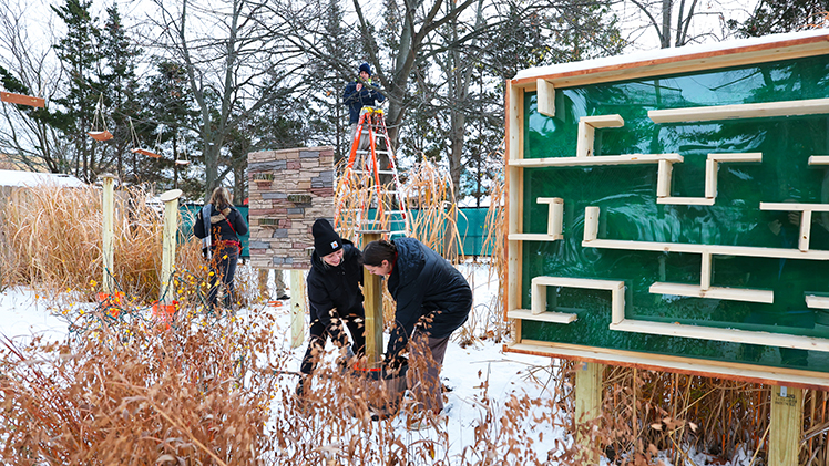 Seniors Madison Sprenger, left, and Nora Beseiso-Shadler, install an obstacle at the Toledo Zoo on Monday, Dec. 1.