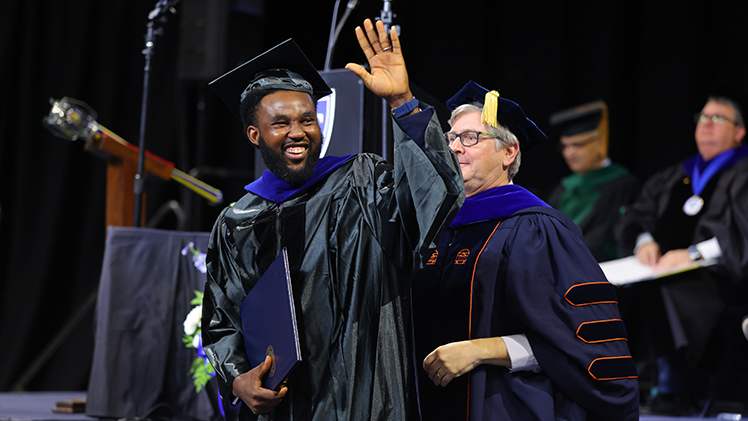 Babatunde Obadawo waves after receiving his Ph.D. in chemistry.