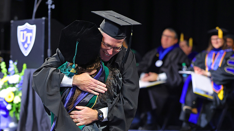 Dr. Zachary Fulton hugs Kylee Fulton following her hooding for graduating with her doctor of physical therapy.