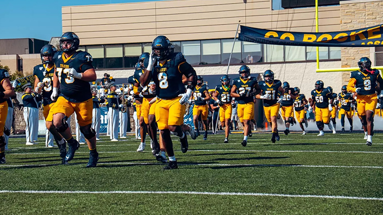 Toledo football players run onto the field before the game.
