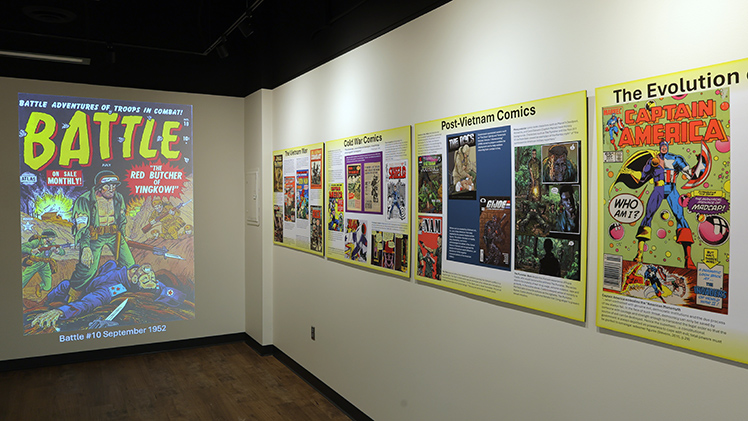 ALT: Photo of comic books on display as part of the “Drawn into Conflict: The Evolution of War Comics,” a recently opened exhibit in Carlson Library South Gallery.