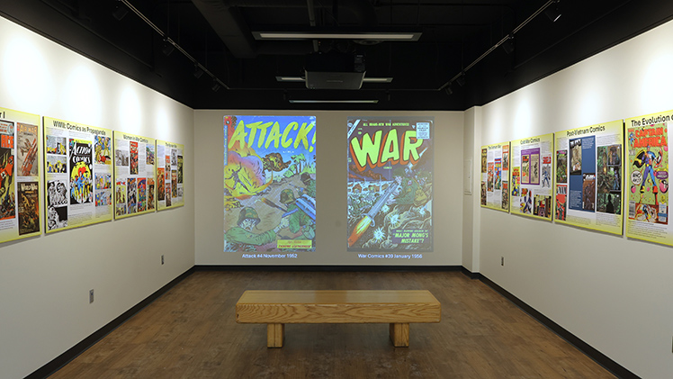 ALT: Photo of comic books on display as part of the “Drawn into Conflict: The Evolution of War Comics,” a recently opened exhibit in Carlson Library South Gallery.