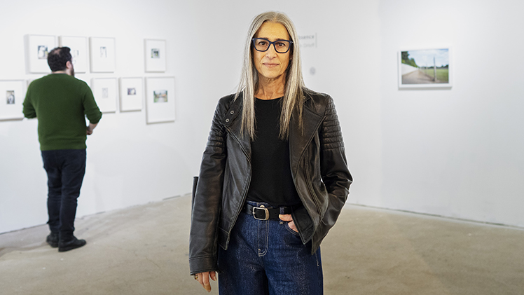 Deborah Orloff, a professor and associate chair of the Department of Art, poses in River House Arts with her solo exhibition “Archive of Absence” behind her.