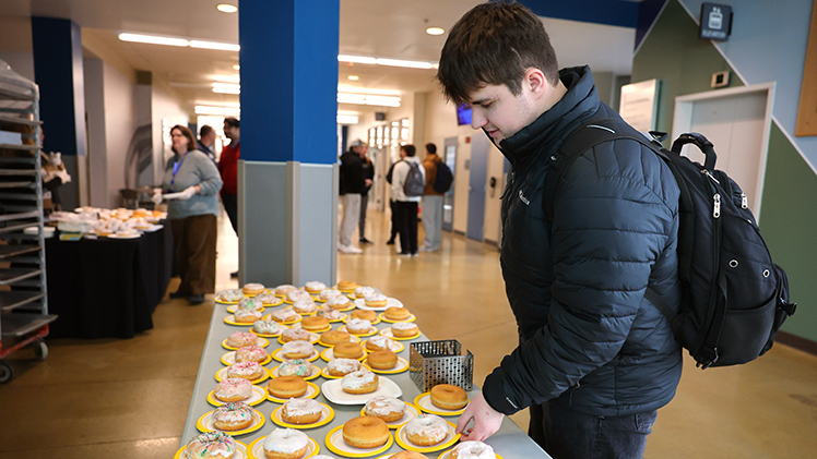 Caden Smith, a sophomore in mechanical engineering, picks out a free donut at Nitschke Hall on Monday. The College of Engineering provided the free treats to welcome back their students from winter break.