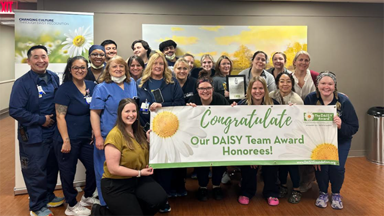 Group photo of the Heart and Vascular Care Unit at the University of Toledo Medical Center holding a sign after winning a national award.
