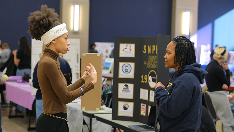 Jatalia Barnes, left, a senior studying information systems, talks with Shania Davis, a third-year pharmacy student, about the Student National Pharmaceutical Association at Tuesday’s Spring Campus Involvement Fair in Thompson Student Union.