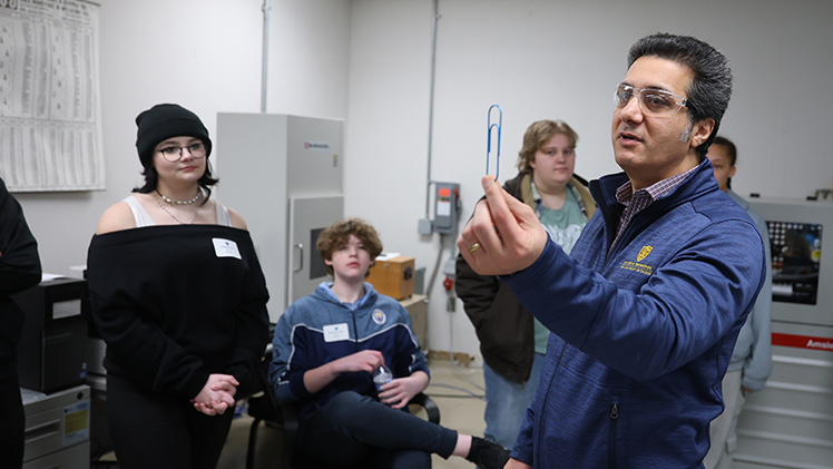 Dr. Meysam Haghshenas, an assistant professor in the Department of Mechanical, Industrial and Manufacturing Engineering teaches high school students about fatigue failure using paperclips during Engineer for a Day, Tuesday, Feb. 24.