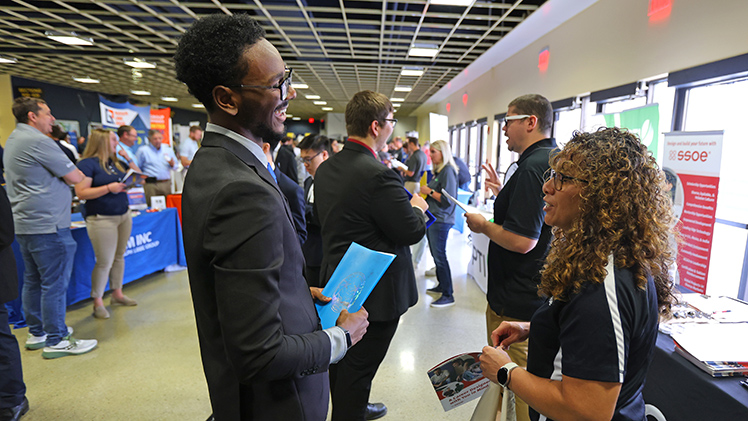 (L to R) Jaden Collins, a sophomore majoring in Electrical Engineering, talks with Zulema Lopez (SSOE) at a College of Engineering Career Expo.