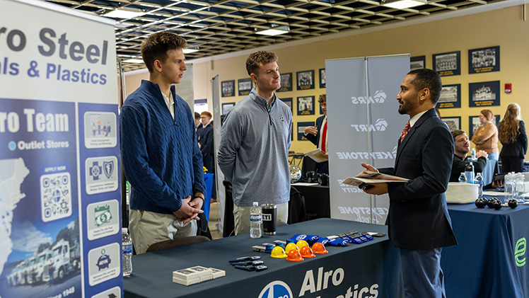 Roshan Muralidhar, a graduate student in applied business analytics, pitches himself to Gordy Hunt and Trevor Pennell, employees at Alro Steel, during UToledo’s John B. and Lillian E. Neff College of Business and Innovation Spring 2026 Job Fair on Thursday in John F. Savage Arena.