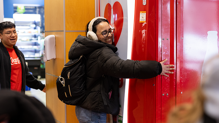 Sonia Garg, a sophomore studying biology, hugs a Coke machine to receive a free soft drink.