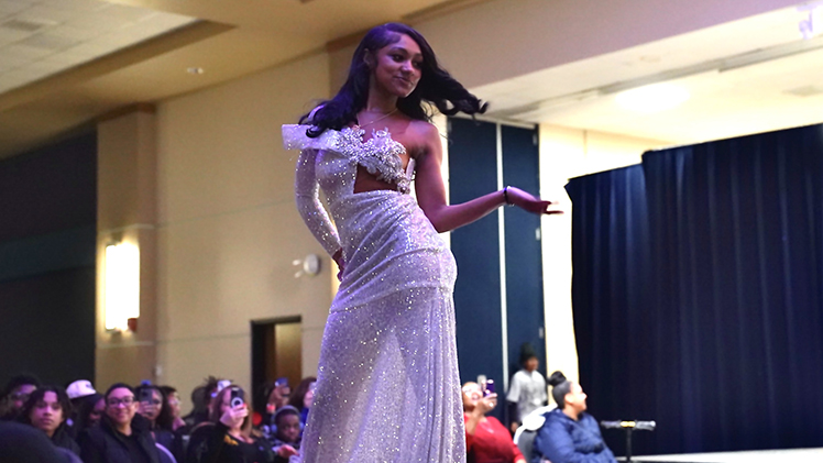 A female student models a fashionable dress on the runway during the 56th annual Fashion Show on Tuesday night in Thompson Student Union Auditorium.