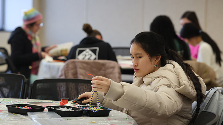 Ellie Nguyen, a sophomore in pre-pharmacy, crafts a beaded cell phone decoration during the Room Makeover: DIY-style event Wednesday afternoon in Thompson Student Union.