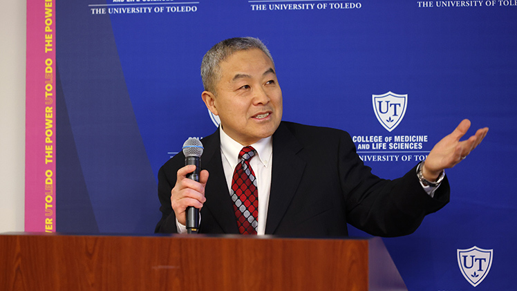 Dr. Jian-Ting Zhang, a professor and the inaugural director of the Northwest Ohio Cancer Research Institute, speaks at a podium.