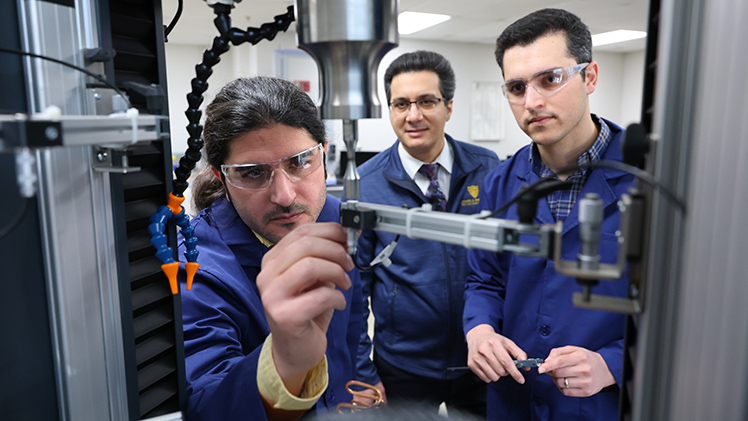 From left, Mohammad Mahtabi, a Ph.D. student in mechanical engineering, Dr. Meysam Haghshenas, associate professor in the Department of Mechanical, Industrial, and Manufacturing Engineering (MIME), and Mojtaba Roshana, a Ph.D. student in mechanical engineering. Haghshenas heads the College of Engineering’s Failure, Fracture and Fatigue Laboratory, where he uses high-tech equipment to study how materials weaken under repeated stresses or strains.