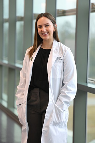 Portrait of Emma Bonnell in a white lab coat. 