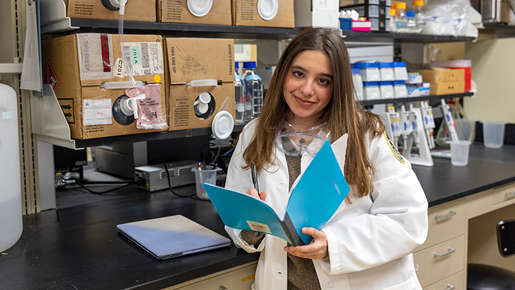 Photo of Mina Nooralden, an honors sophomore in pharmacy with a minor in chemistry, working in a research lab.