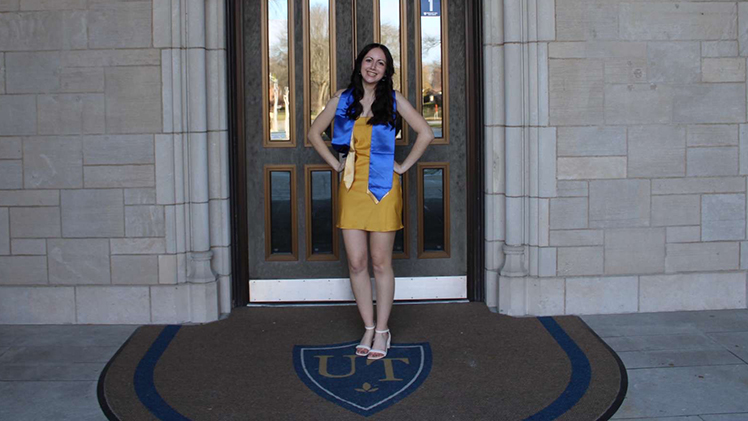 Photo of biology student Isabel Kennedy posing in front of a door in UHall.
