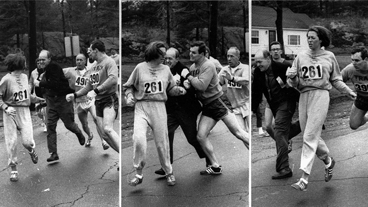 A woman, listed only as K. Switzer of Syracuse, found herself about to be thrown out of the normally all-male Boston Marathon when a husky companion, Thomas Miller of Syracuse, threw a block that tossed a race official out of the running instead, April 19, 1967 in Hopkinton, Mass. (Boston Traveler photo by Harry Trask)