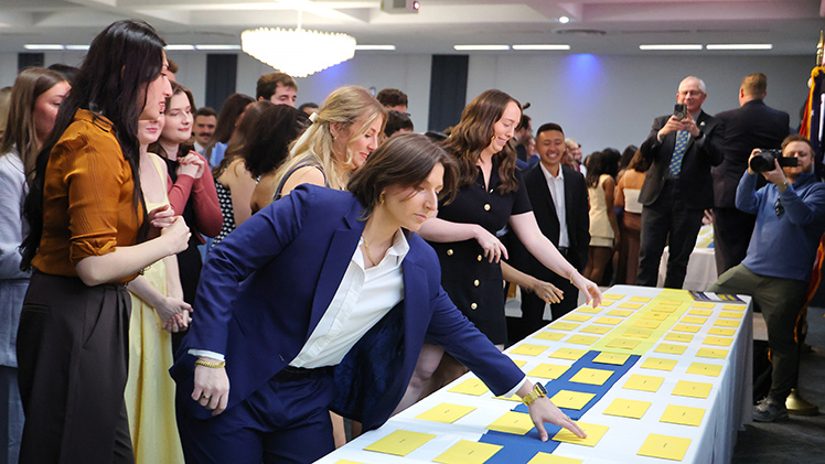 Photo of Elizabeth Schumacher as she reaches for her Match Day envelope. She matched with her top choice at the Ohio State University’s Obstetrics and Gynecology Residency program, said having her UToledo instructors available as mentors was pivotal to her residency match.