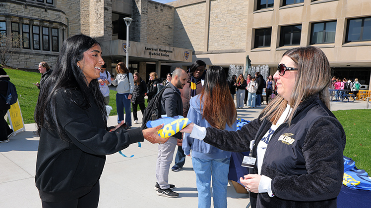 Manisha Girn, a freshman in bioengineering, receives a free T-shirt from Jessica Bergman, manager of immigration compliance in the Office of International Student and Scholar Services.