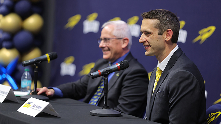 Tom Moreland speaks into a microphone at his press conference with UToledo President James Holloway sitting next to him.