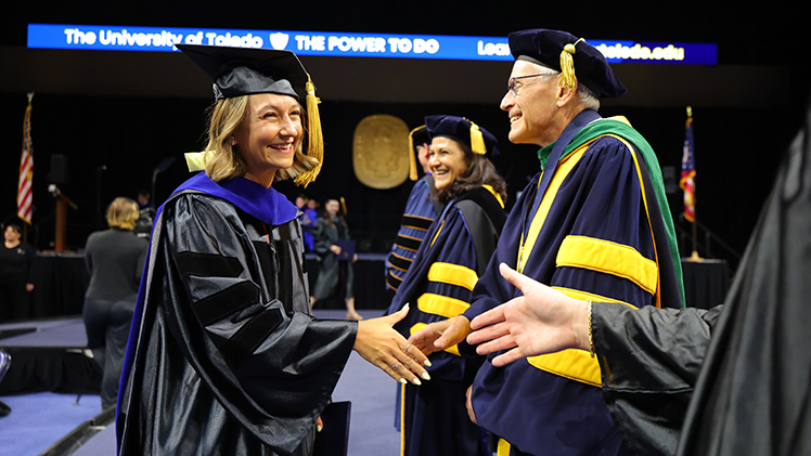 Lauren Kramer shakes hands with a University official after crossing the stage during the ceremony. Kramer graduated with a doctorate in clinical psychology.