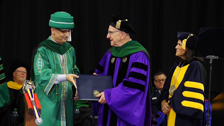 Dr. David J. Skorton, center, president and CEO of the Association of American Medical Colleges (AAMC), who served as the commencement speaker, receives an honorary Doctor of Science, honoris causa, from Dr. Imran Ali, left, dean of the College of Medicine and Life Sciences, as Dr. Eleanore Awadalla, UToledo trustee and vice chair, right, looks on.