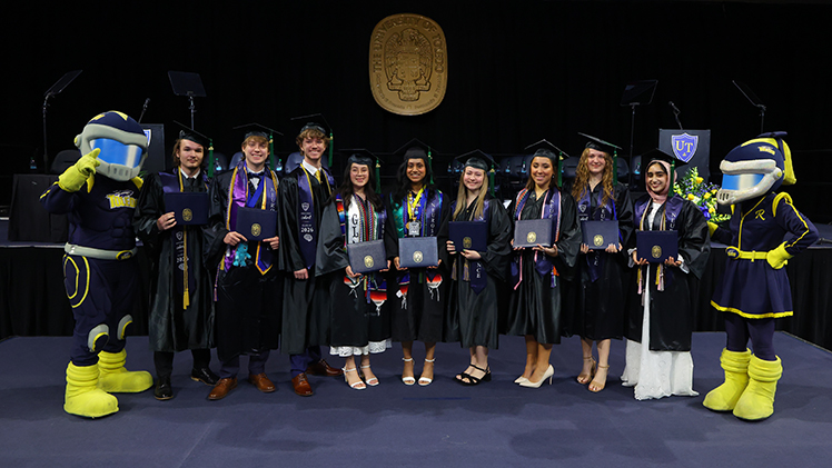 Graduates from The University of Toledo’s inaugural bachelor’s degree program in neuroscience pose on stage with Dr. David Giovannucci at the May 2 commencement ceremony.