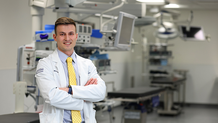 Portrait of Matthew Folkman posing in a medical lab.