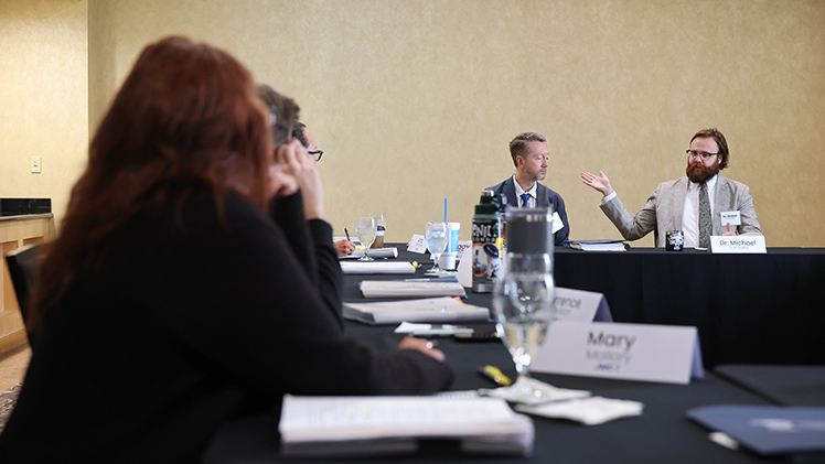 Dr. Clint Condra, left, the assistant director of education outreach at the Institute of American Constitutional Thought and Leadership, listens as Dr. Michael Gonzalez, right, the senior associate director of the Institute, speaks during one of two simultaneous professional development programs for more than 40 middle and high school teachers throughout the region this week at UToledo.