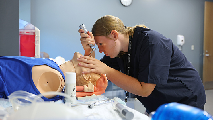 CampMed attendee Megan Recker practices intubation on a medical simulator. The free, two-day program introduces rising ninth-graders to careers in science and medicine.