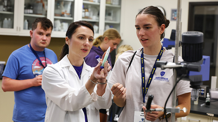 Dr. Gabriella Baki, a professor and director of the undergraduate Cosmetic Science and Formulation Design Program in the College of Pharmacy and Pharmaceutical Sciences, assists camper Mary Murphy with an exercise during the Pharmacy and Science Career Camp.