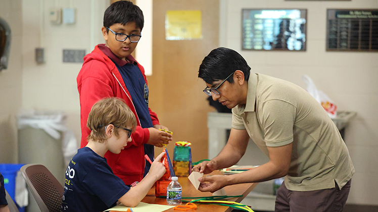 Ruben Mamani, a graduate student in mathematics in the College of Natural Sciences and Mathematics, gives instructions to Nehemiah Tate during a Math Circle Summer Session at UToledo.