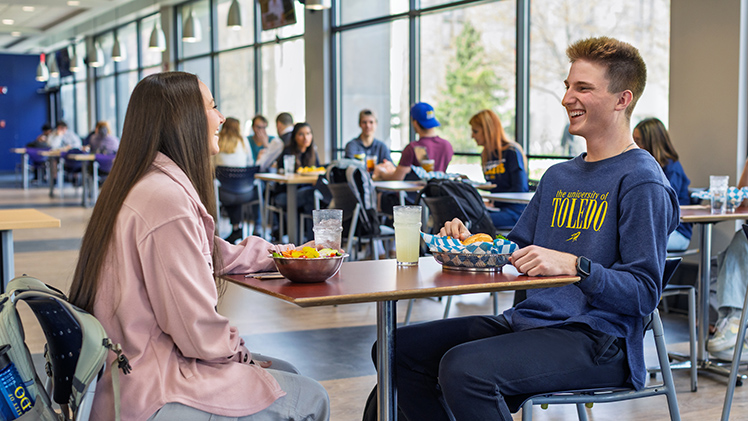 A female and male UToledo student have lunch in Thompson Student Union.