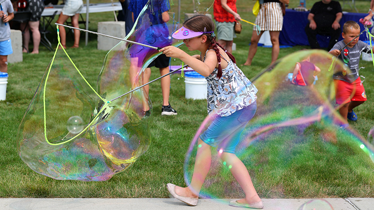 Ravenna Gaietto, 10, creates huge soap bubbles outside the Young Artist Area.