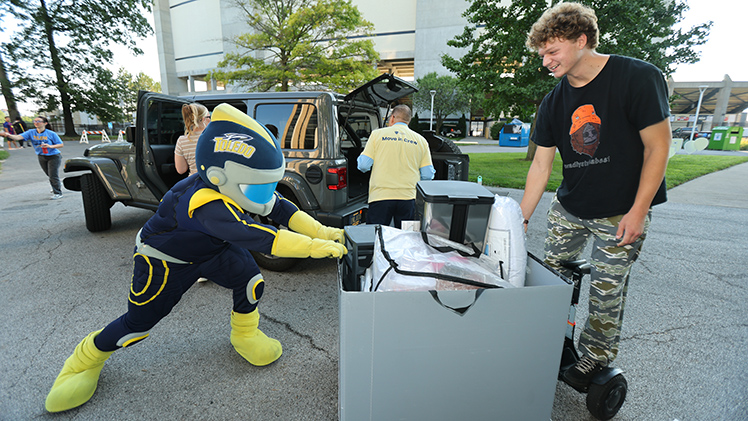 Nick Kinzel, who was helping a friend move into a residence hall, watches as Rocky struggles to move a bin.