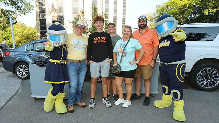 Gentry Smith, third from left, a media communication major from Wilmington, Ohio, poses with his family, Rocky, Rocksy and President Holloway.
