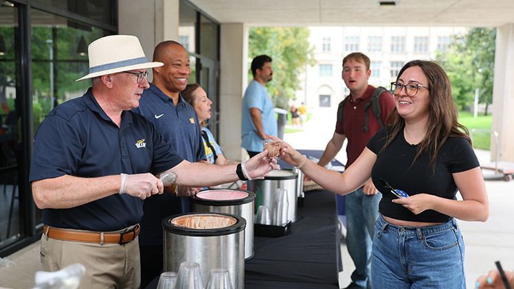 Ranie Roesch, a senior majoring in medical laboratory science, takes a scoop of chocolate ice cream from UToledo President James Holloway as Dr. Sammy Spann, vice provost and dean of students, watches during the annual Sundae on a Monday.