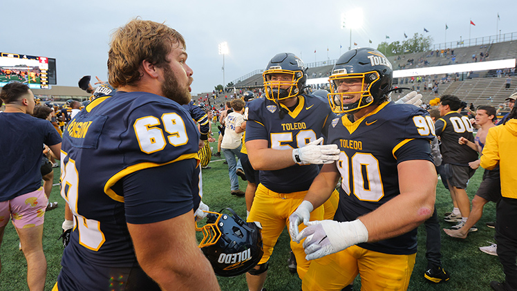 The Toledo football team celebrates on the field after pulling off one of the most unlikely comebacks in program history, rallying to stun Temple, 49-48, in an overtime thriller at Glass Bowl Stadium on Saturday.