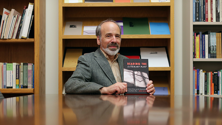 Dr. Andrew Mattison poses for a portrait with his newly published book "Reading the Literary Past."