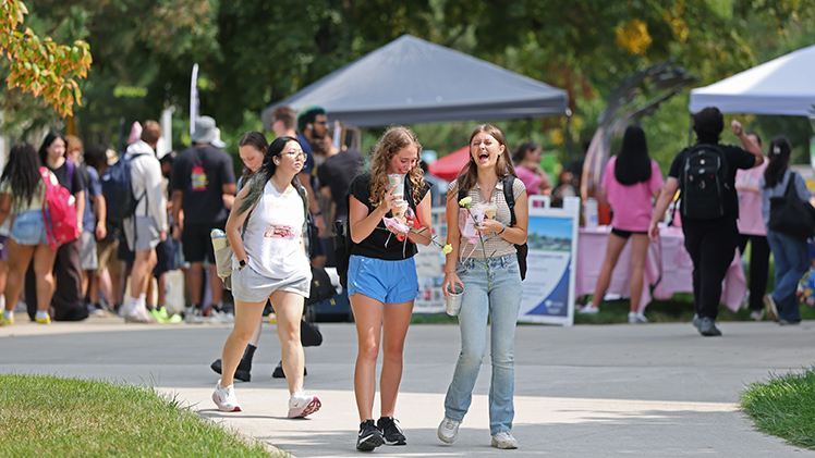 Leah Chmielewski, left, and Annabelle Barney, both freshmen majoring in nursing, laugh as they leave the Campus Involvement Fair.